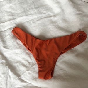 Orange cheeky bathing suit bottoms with ruching